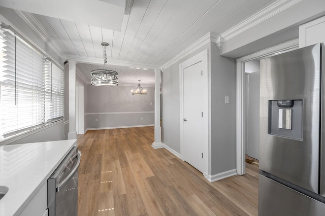 kitchen with pendant lighting, light hardwood / wood-style flooring, stainless steel appliances, and crown molding