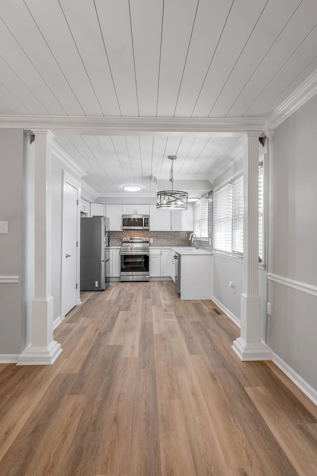 interior space featuring light hardwood / wood-style flooring, ornate columns, and ornamental molding