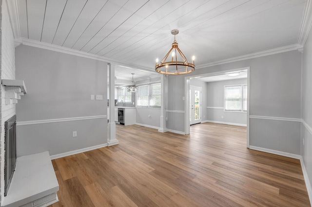 unfurnished living room with ornamental molding, a wealth of natural light, hardwood / wood-style floors, and a fireplace