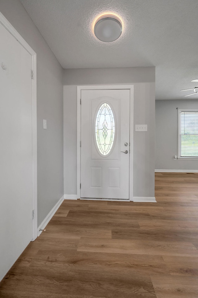 entryway featuring a textured ceiling, hardwood / wood-style floors, and ceiling fan