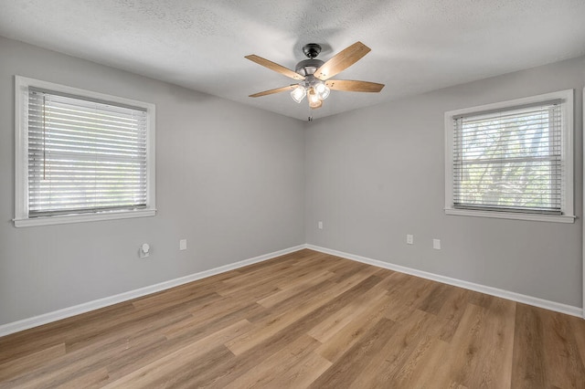 empty room featuring a textured ceiling, ceiling fan, and light hardwood / wood-style floors