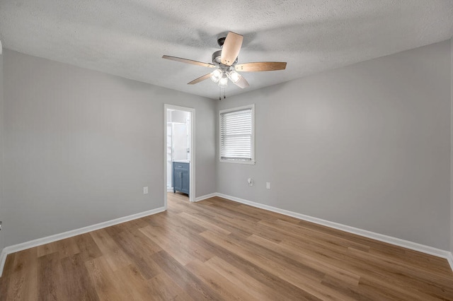 spare room featuring light hardwood / wood-style floors, ceiling fan, and a textured ceiling