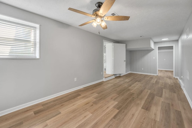 interior space with ceiling fan, a textured ceiling, and light wood-type flooring