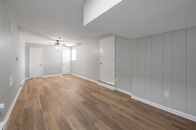 empty room featuring ceiling fan, hardwood / wood-style flooring, and a textured ceiling