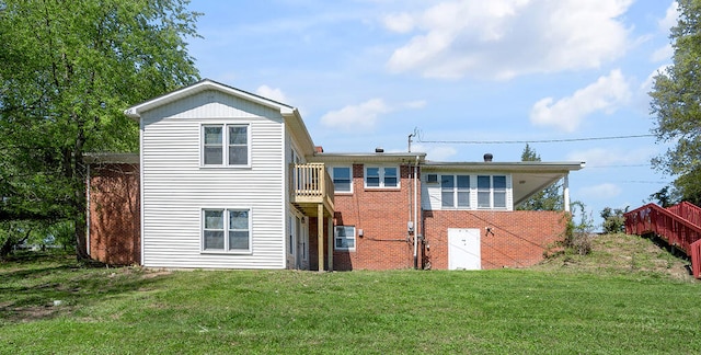 back of property with a balcony and a yard