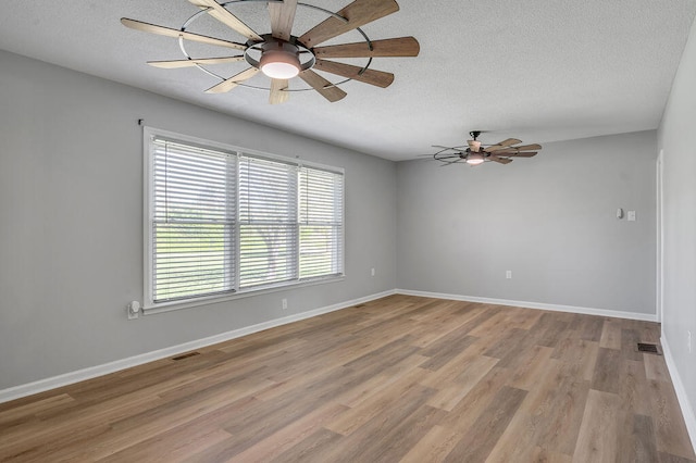 unfurnished room with wood-type flooring, a textured ceiling, and ceiling fan