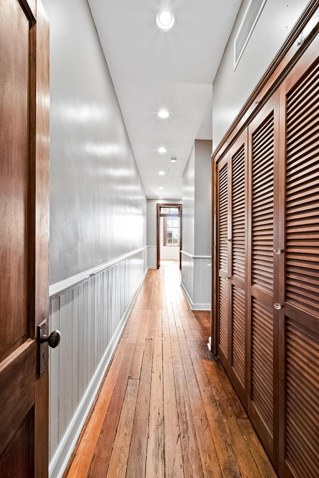 corridor with hardwood / wood-style flooring