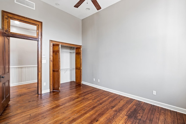 unfurnished bedroom with a closet, dark wood-type flooring, and ceiling fan