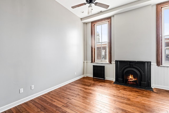 unfurnished living room featuring radiator, ceiling fan, hardwood / wood-style floors, and lofted ceiling