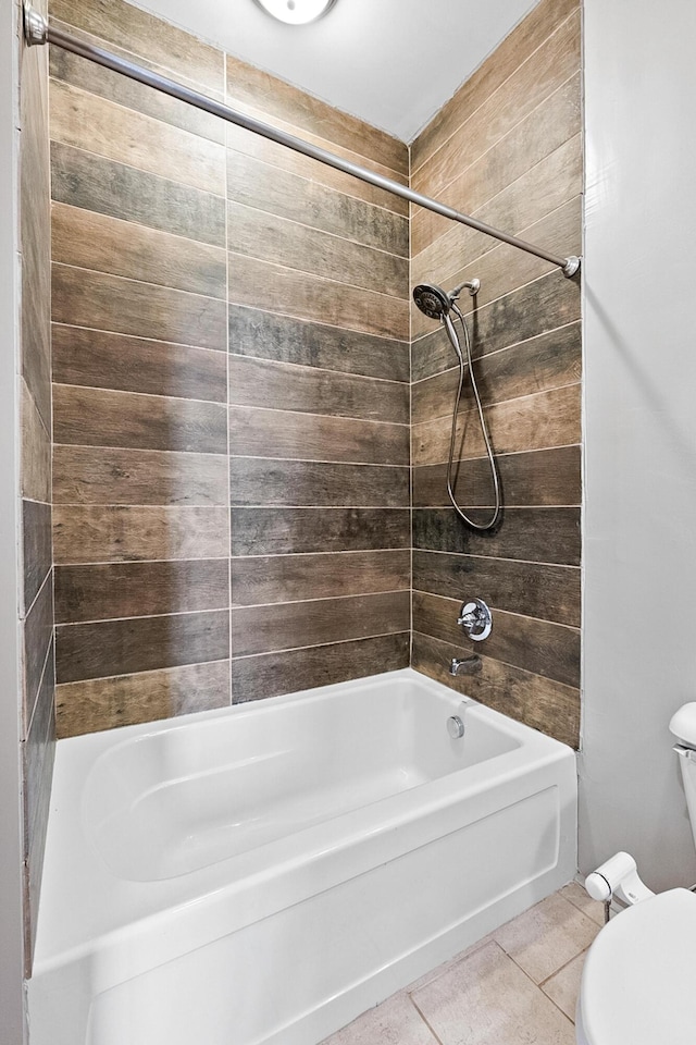 bathroom with toilet, tile flooring, and tiled shower / bath combo