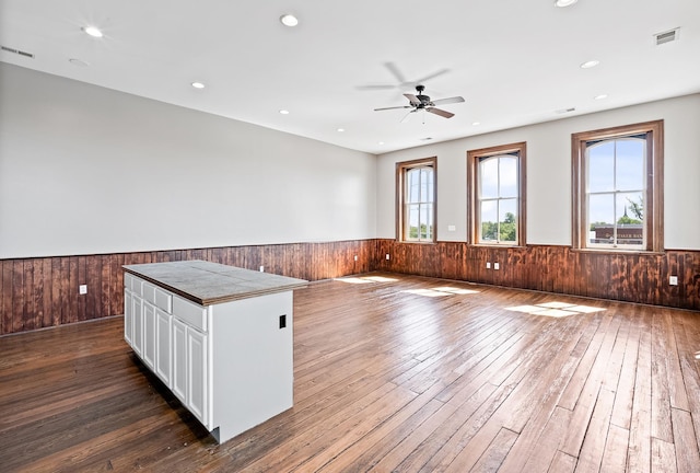 kitchen featuring white cabinets, wood-type flooring, ceiling fan, and a kitchen island