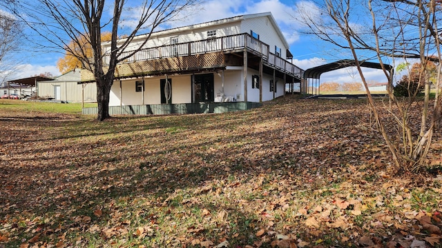 rear view of house with a carport and a yard