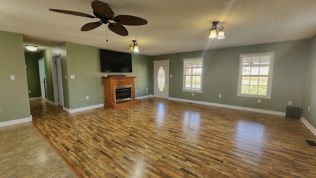 unfurnished living room featuring ceiling fan and tile flooring