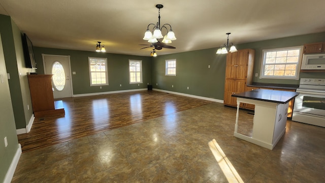 kitchen featuring hanging light fixtures, white appliances, plenty of natural light, and dark wood-type flooring