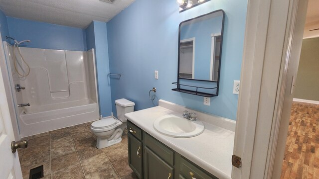 full bathroom featuring large vanity, a textured ceiling, hardwood / wood-style floors, washtub / shower combination, and toilet