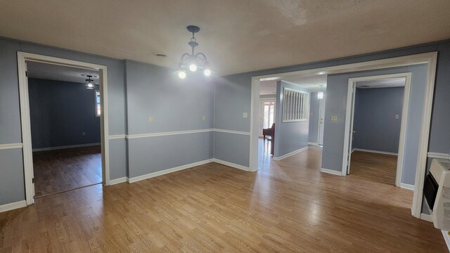 spare room featuring hardwood / wood-style flooring and a chandelier