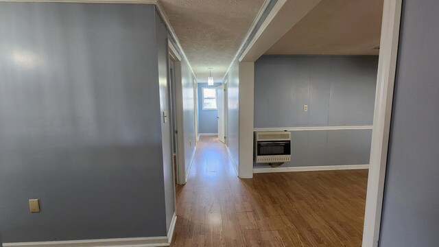 corridor featuring a textured ceiling and hardwood / wood-style floors