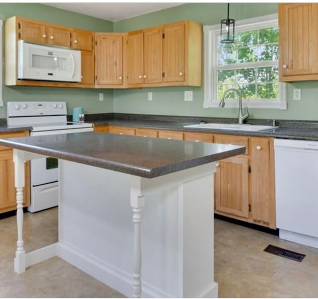 kitchen with a center island, pendant lighting, white appliances, sink, and light tile floors