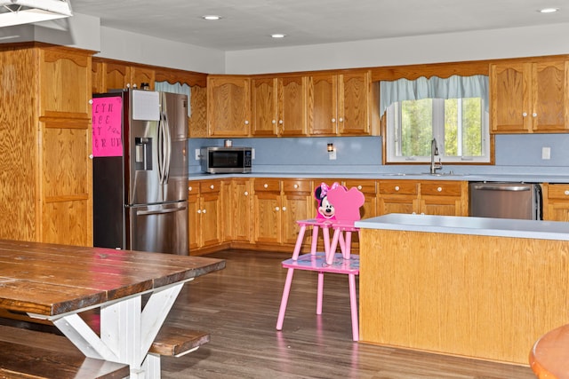 kitchen featuring stainless steel appliances, dark wood-type flooring, and sink