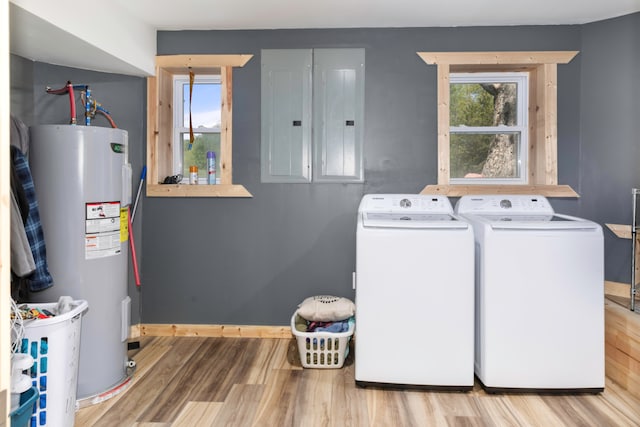 laundry area with light hardwood / wood-style flooring, electric water heater, independent washer and dryer, and electric panel