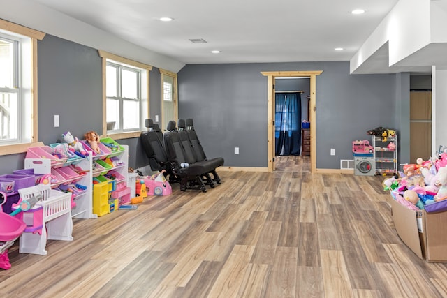 game room with light hardwood / wood-style flooring and a healthy amount of sunlight