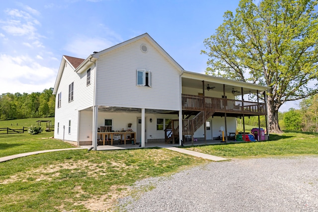 back of property with a patio area, a lawn, and ceiling fan