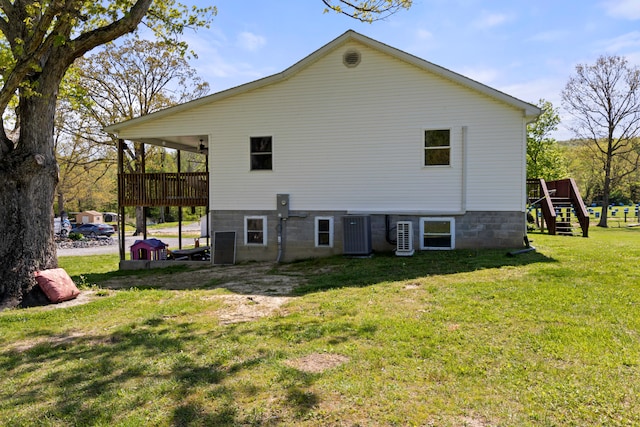 rear view of property with a lawn and a playground