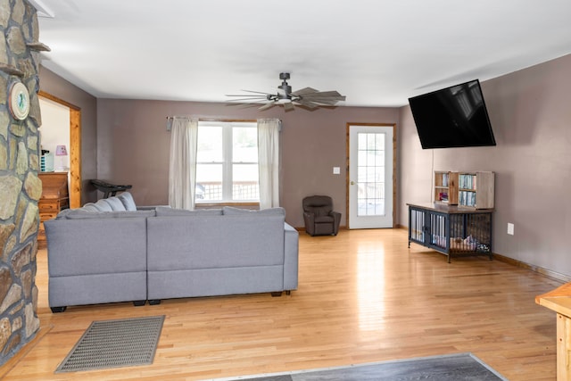 living room with light hardwood / wood-style flooring, ceiling fan, and a wealth of natural light