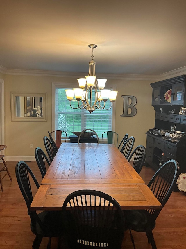 dining room with a notable chandelier, hardwood / wood-style floors, and crown molding