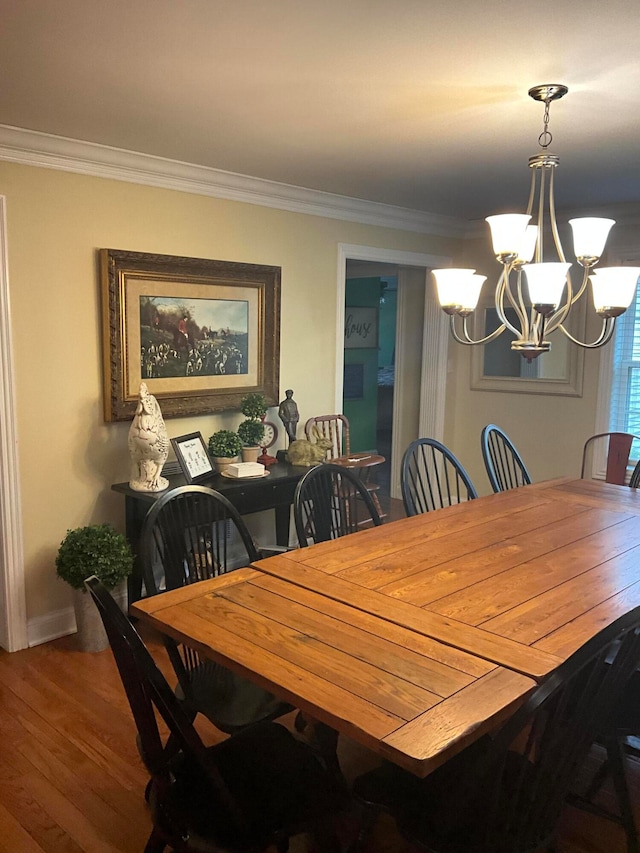 dining room with an inviting chandelier, crown molding, and hardwood / wood-style floors