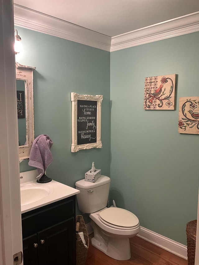 bathroom featuring toilet, crown molding, vanity, and wood-type flooring