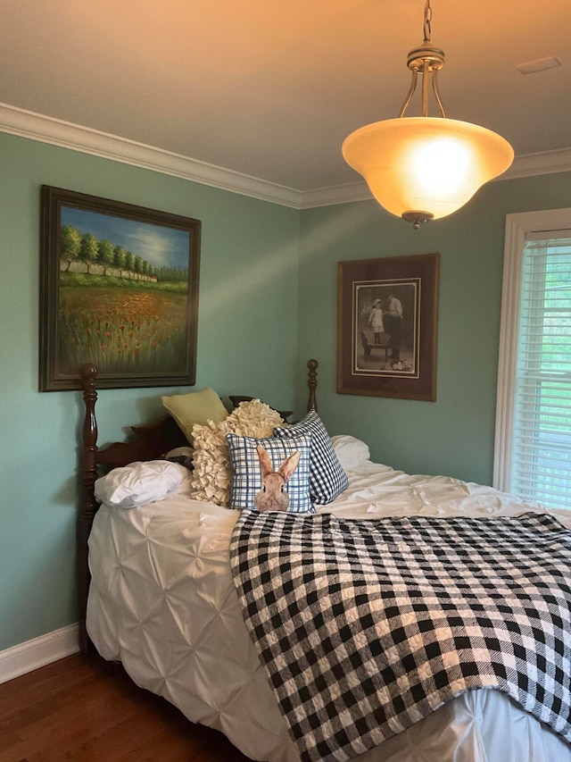 bedroom with crown molding and dark hardwood / wood-style flooring