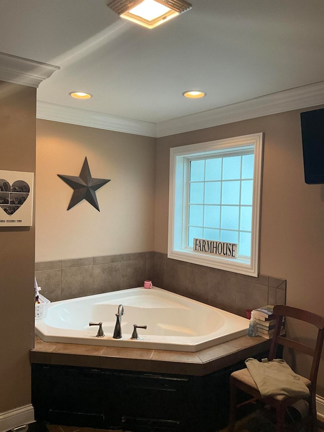 bathroom with ornamental molding and tiled bath