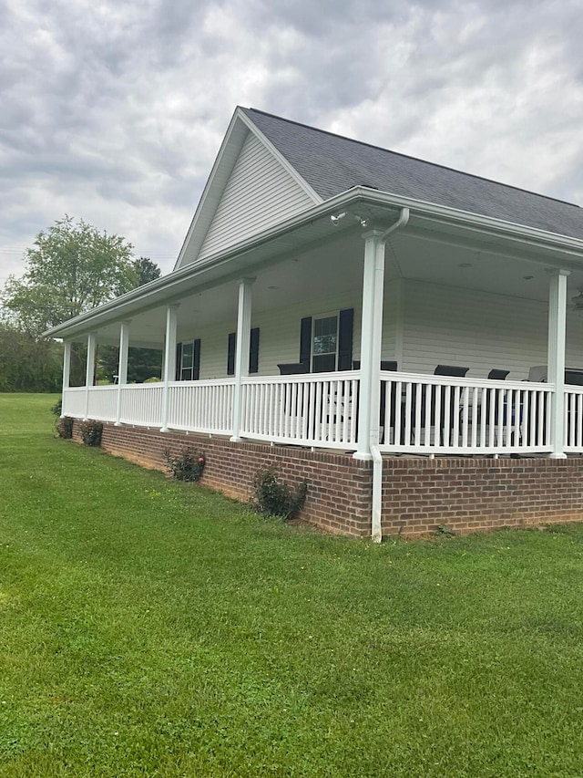 view of side of home with a yard and covered porch