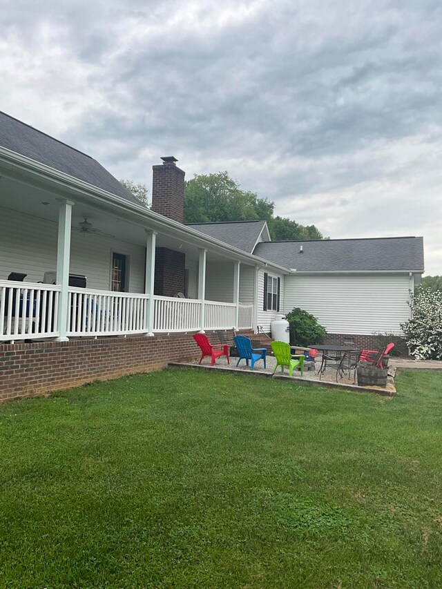 rear view of house with a patio and a lawn