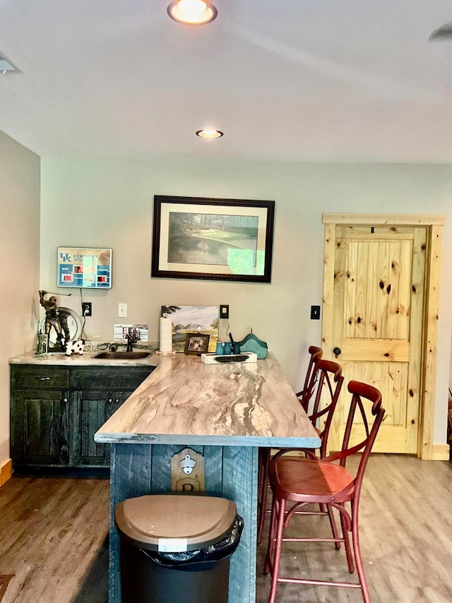 bar with sink and wood-type flooring