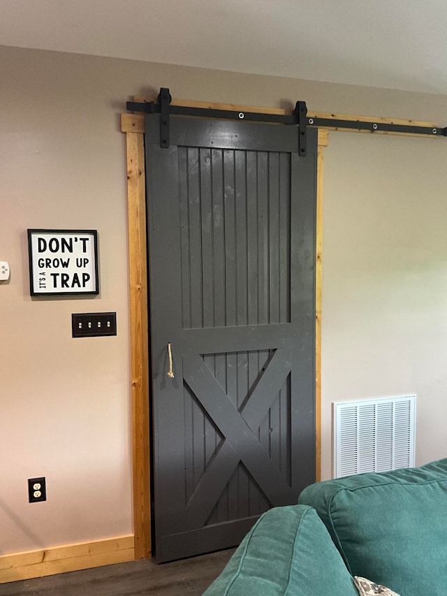 bedroom featuring hardwood / wood-style floors and a barn door