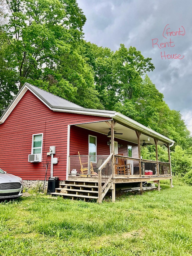 view of front of home featuring cooling unit, a wooden deck, and a front lawn