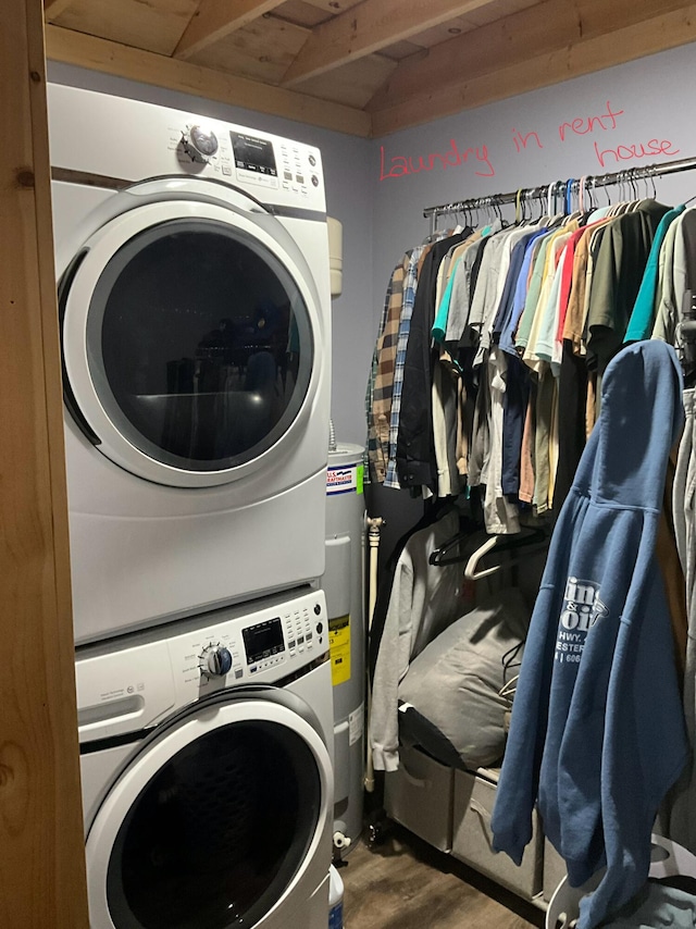 laundry area featuring hardwood / wood-style flooring, stacked washer and clothes dryer, and water heater