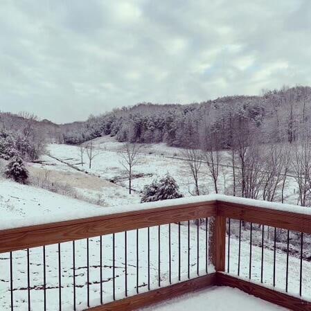 view of snow covered back of property