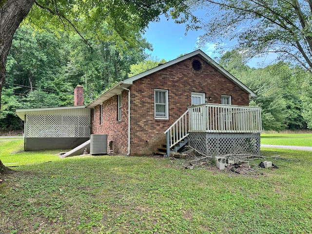 back of property featuring a yard, central AC, and a deck