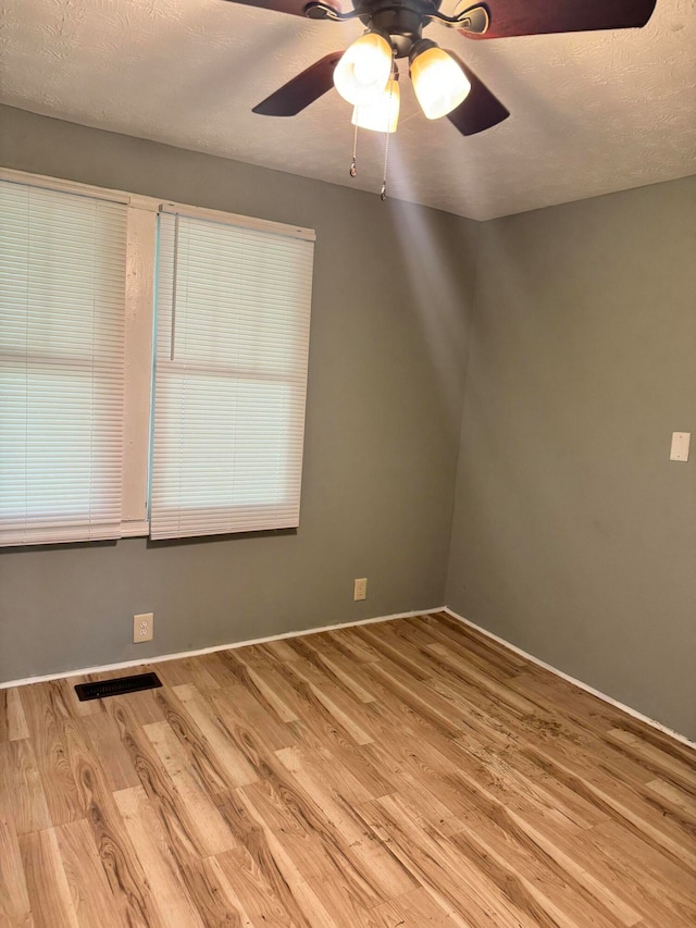 unfurnished room featuring a textured ceiling, wood-type flooring, and ceiling fan