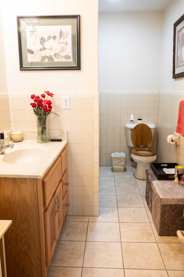 bathroom with tile walls, vanity, tile floors, and toilet