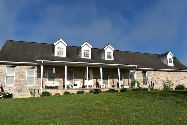 cape cod-style house featuring a front lawn and a porch