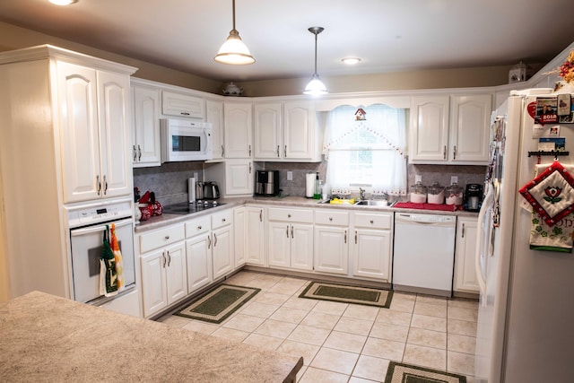 kitchen with white appliances, tasteful backsplash, light tile floors, and white cabinetry