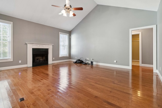 unfurnished living room featuring ceiling fan, high vaulted ceiling, and wood-type flooring