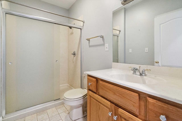 bathroom featuring vanity, tile patterned flooring, toilet, and walk in shower