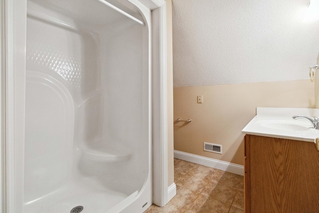 bathroom featuring vanity, tile patterned flooring, and walk in shower