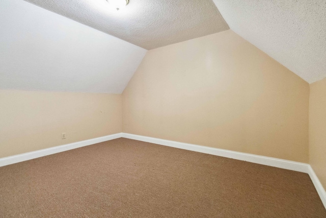 bonus room featuring lofted ceiling, a textured ceiling, and carpet floors