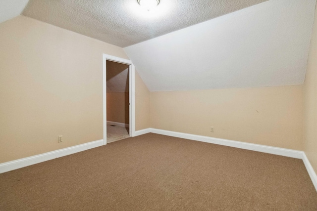 bonus room featuring a textured ceiling, carpet, and vaulted ceiling